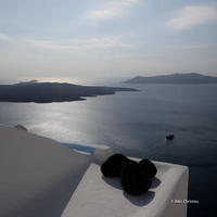 Volcano and Thirasia as seen from the Caldera in Fira, noon time