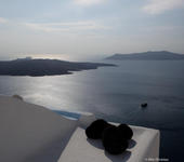 Volcano and Thirasia as seen from the Caldera in Fira, noon time