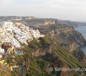 A panoramic photo of Fira, taken from Firostefani. The sun is going down.