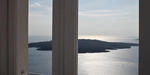 A balcony door to the Volcano. Blue sea and Santorini volcano from inside a balcony door.
